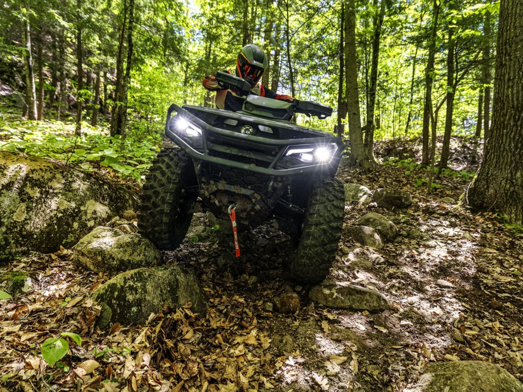 2026 Can-Am Outlander 1000R 4x4 V-twin accelerating on a forest trail